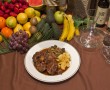 Plato de rabo de toro acompañado de patatas fritas y variedad de verduras